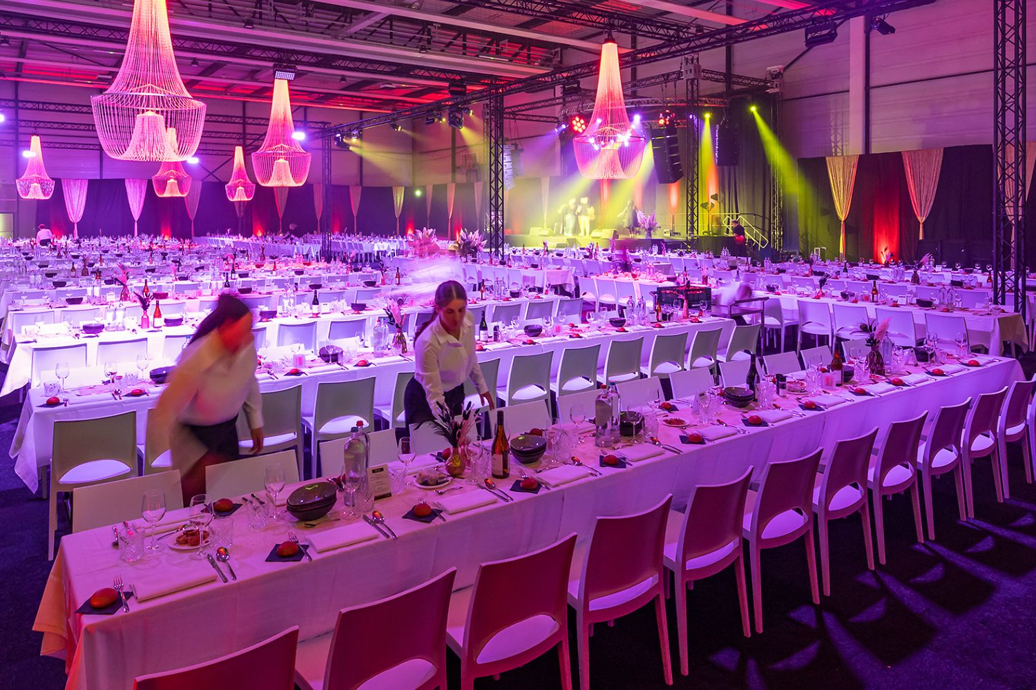 Groot galadiner met luxe tafelaankleding en sfeervolle verlichting voor een bedrijfsevenement.