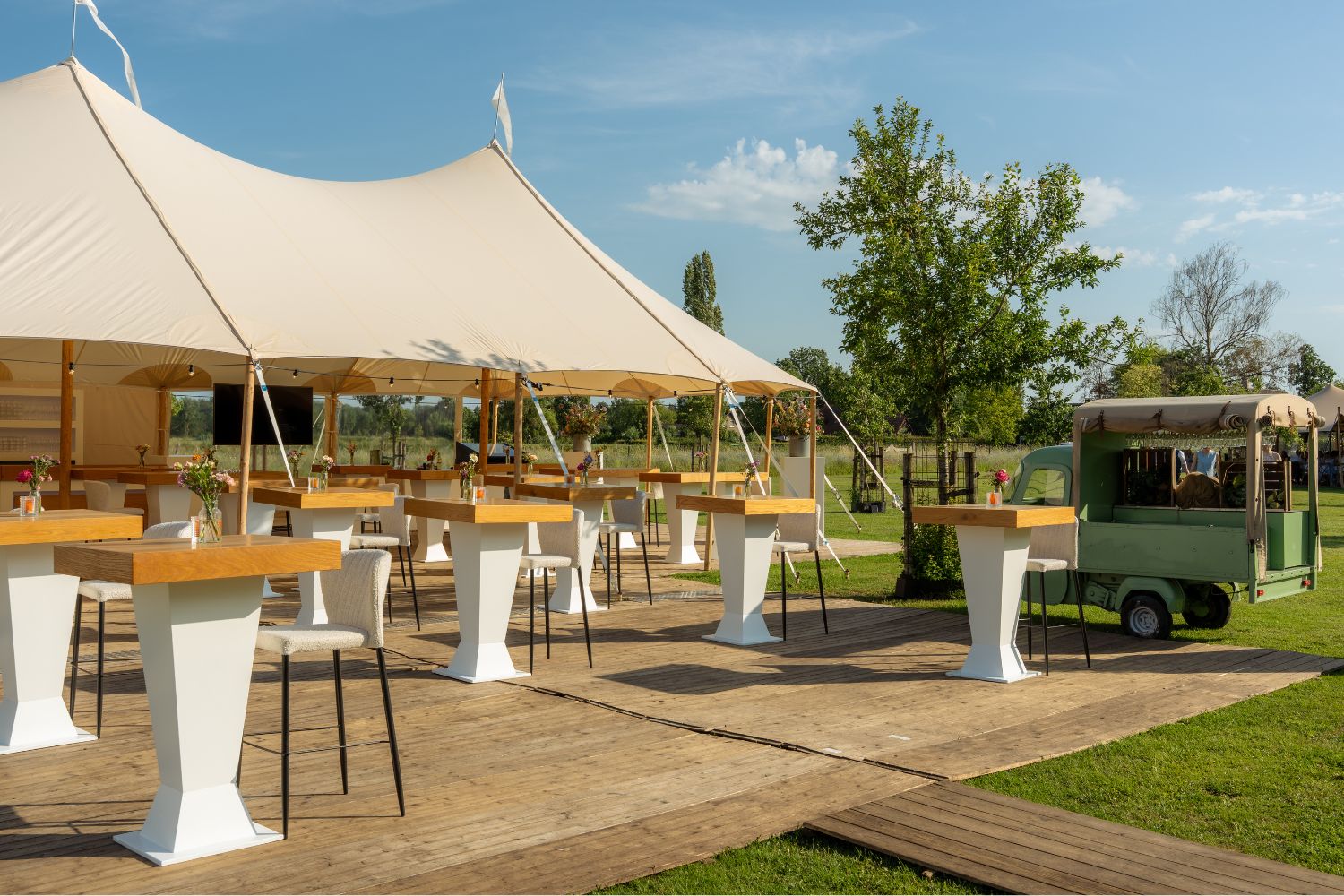 Luxe sailclothtent met stijlvolle inrichting voor een bedrijfsfeest of bruiloft op locatie.