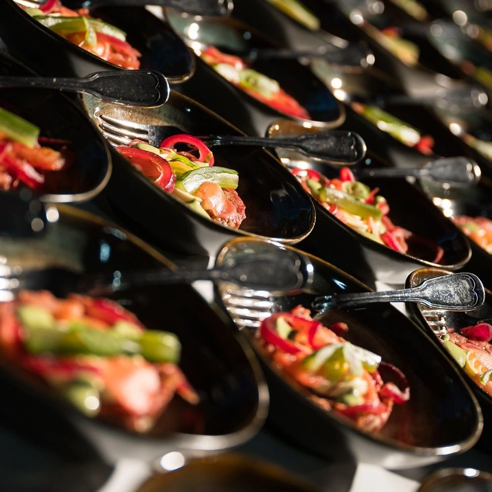 Luxe gerechten met verse groenten, individueel geserveerd tijdens een personeelsfeest.