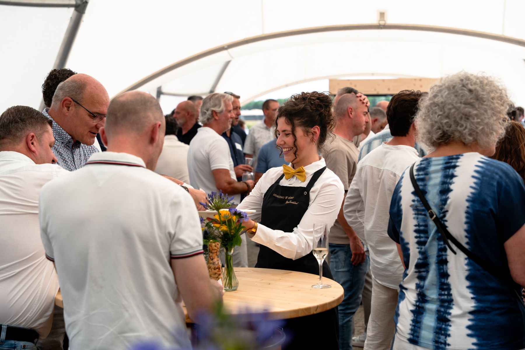 Medewerker van Ria Joosten ondersteunt gasten tijdens de uitvoering van een zakelijk evenement.